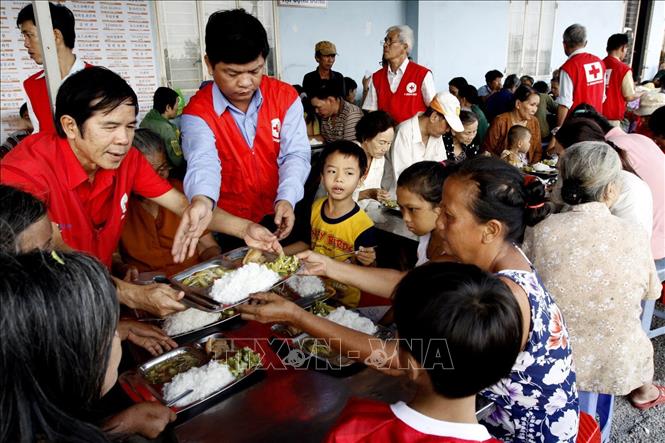 Trong ảnh: Hội Chữ thập đỏ quận Bình Tân cùng các đơn vị bảo trợ tổ chức “Bếp ăn tình thương”, thường xuyên cung cấp suất cơm cho người nghèo, người khuyết tật, trẻ em lang thang (năm 2013). Ảnh: Thế Anh-TTXVN