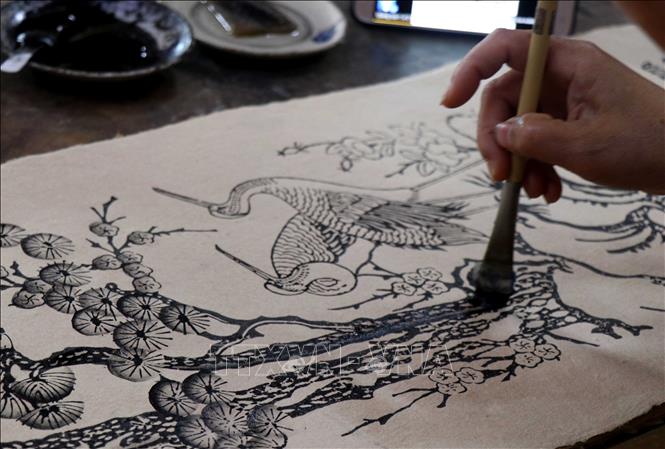 Trong ảnh: Nghệ nhân vẽ tranh Đông Hồ. Ảnh: Đinh Văn Nhiều - TTXVN