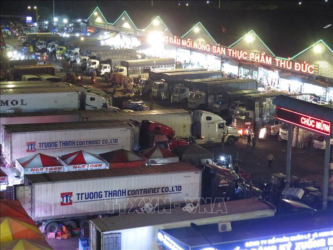 Trong ảnh: Các xe container tấp nập đưa hàng vào chợ nông sản Thủ Đức. Ảnh: Hồng Nhung - TTXVN 