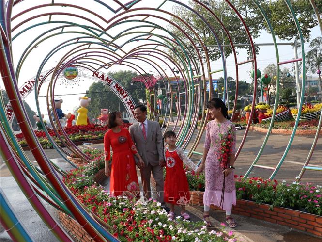 Trong ảnh: Người dân ghi lại những khoảnh khắc đẹp tại đường hoa “ Vui Xuân” trên đường Hùng Vương, thành phố Đồng Xoài, tỉnh Bình Phước.  Ảnh: Dương Chí Tưởng-TTXVN