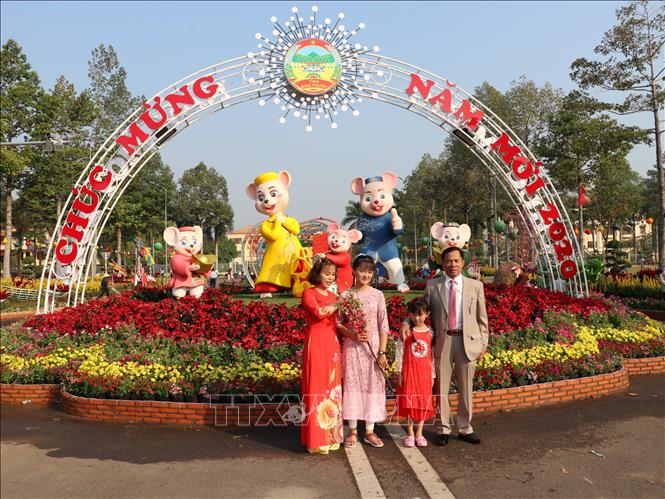 Trong ảnh: Người dân ghi lại những khoảnh khắc đẹp tại đường hoa “ Vui Xuân” trên đường Hùng Vương, thành phố Đồng Xoài, tỉnh Bình Phước.  Ảnh: Dương Chí Tưởng-TTXVN