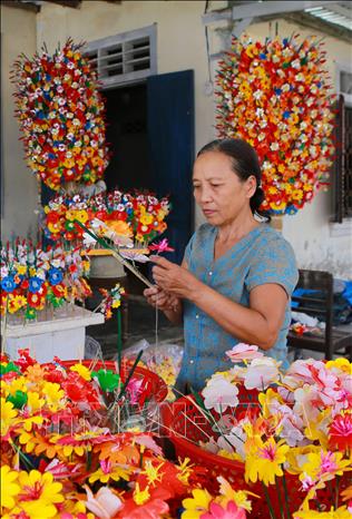 Trong ảnh: Làm hoa giấy tại một hộ gia đình ở làng Thanh Tiên. Ảnh: Hồ Cầu-TTXVN