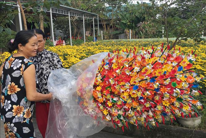Trong ảnh: Người dân đến mua hoa giấy tại một hộ gia đình ở làng Thanh Tiên. Ảnh: Hồ Cầu-TTXVN
