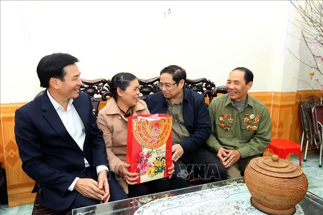 Trong ảnh: Trưởng ban Tổ chức Trung ương Phạm Minh Chính tặng quà gia đình có công với cách mạng. Ảnh: Phan Tuấn Anh - TTXVN