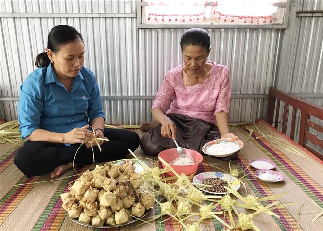 Trong ảnh: Bà Neáng Phương ở xã Ô Lâm, Tri Tôn (An Giang) - người có hơn 40 năm gắn bó với bánh Kà tum (bìa phải) đang phối trộn các nguyên liệu chuẩn bị gói bánh. Ảnh: Công Mạo-TTXVN