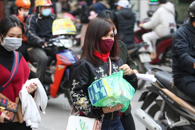 Trong ảnh: Người dân lùng mua khẩu trang dù giá bị đội lên rất cao. Ảnh: Thành Đạt - TTXVN