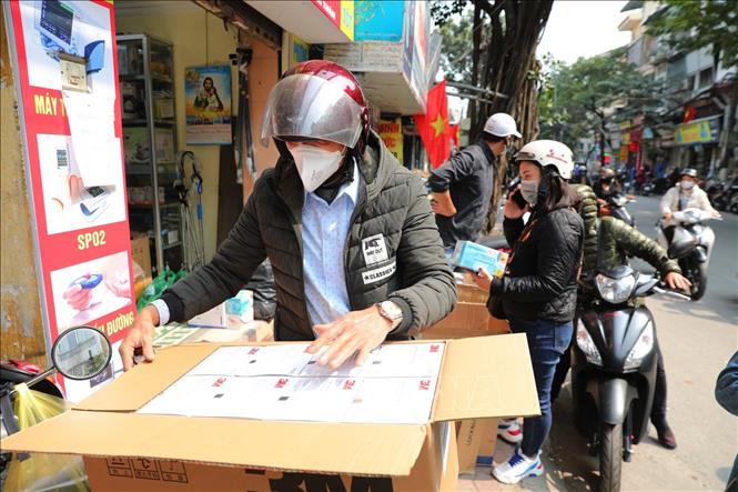 Trong ảnh: Trên phố Phương Mai (quận Đống Đa), các buôn lái thu mua khẩu trang để bán lại cho các cửa hàng nhỏ lẻ khác. Ảnh: Thành Đạt - TTXVN