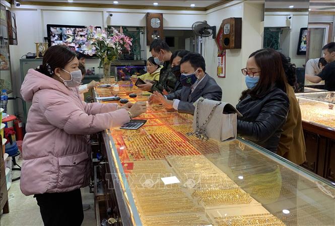 Trong ảnh: Để phòng tránh dịch bệnh do virus Corona đang có những diễn biến phức tạp, người dân và nhân viên bán vàng đều đeo khẩu trang khi giao dịch tại cửa hàng vàng, bạc Ngọc Chiến (thành phố Hưng Yên). Ảnh: Phạm Kiên - TTXVN