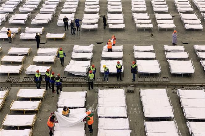 Trong ảnh: Công nhân lắp đặt các giường bệnh chuẩn bị cho bệnh nhân nhiễm virus corona chủng mới tại một trung tâm triển lãm được chuyển đổi thành bệnh viện dã chiến ở Hồ Bắc, Trung Quốc ngày 4/2/2020. Ảnh: AFP/TTXVN