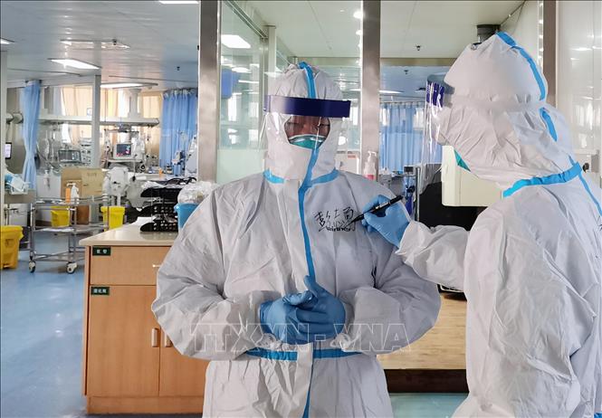 Trong ảnh: Nhân viên y tế viết tên lên áo tại khoa cách ly điều trị cho bệnh nhân nhiễm virus corona của bệnh viện Zhongnan ở Vũ Hán, tỉnh Hồ Bắc, Trung Quốc, ngày 5/2/2020. Ảnh: THX/TTXVN