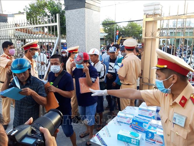 Trong ảnh: Cán bộ Phòng Cảnh sát giao thông, Công an tỉnh Bạc Liêu phát khẩu trang miễn phí cho người dân. Ảnh: Huỳnh Sử - TTXVN