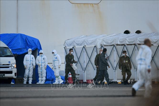 Trong ảnh: Nhân viên y tế làm nhiệm vụ gần du thuyền Diamond Princess bị cách ly tại cảng Yokohama, Nhật Bản ngày 13/2/2020. Ảnh: AFP/TTXVN