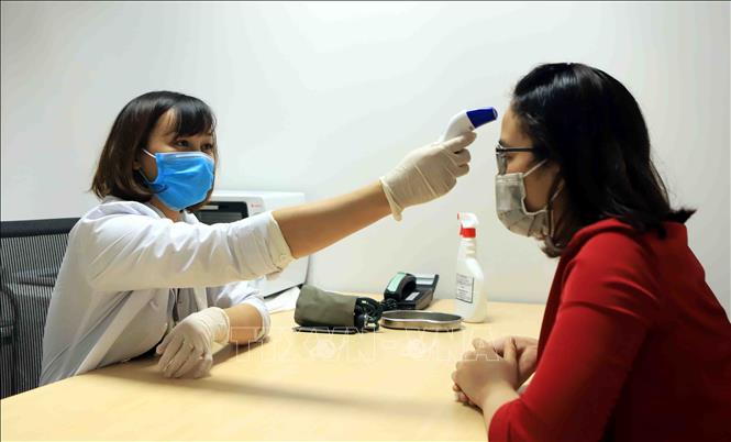 Trong ảnh: Đo nhiệt độ cho công nhân tại phòng y tế Công ty TNHH sản xuất hàng may mặc Việt Nam (TAL), khu công nghiệp Bá Thiện 2 (huyện Bình Xuyên). Ảnh: Hoàng Hùng - TTXVN