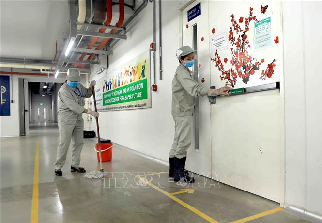 Trong ảnh: Lau sàn nhà và tay nắm cửa bằng dung dịch sát khuẩn tại Công ty TNHH sản xuất hàng may mặc Việt Nam (TAL), khu công nghiệp Bá Thiện 2 (huyện Bình Xuyên). Ảnh: Hoàng Hùng - TTXVN