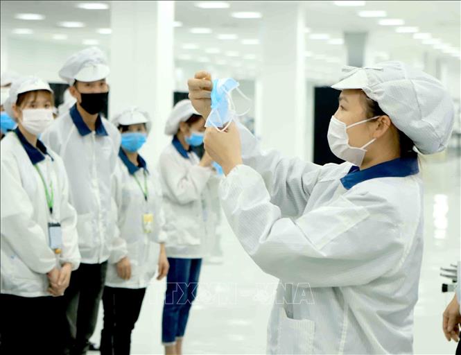 Trong ảnh: Công ty TNHH Compal Việt Nam trong khu công nghiệp Bá Thiện 1 (huyện Bình Xuyên) hướng dẫn cho công nhân đeo khẩu trang đúng cách để phòng chống dịch COVID-19. Ảnh: Hoàng Hùng - TTXVN