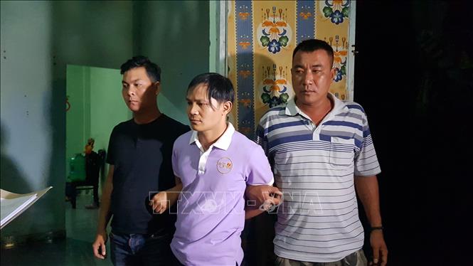 Trong ảnh: Đối tượng Ngân (ở giữa) bị lực lượng chức năng bắt giữ. Ảnh: Đậu Tất Thành – TTXVN 
