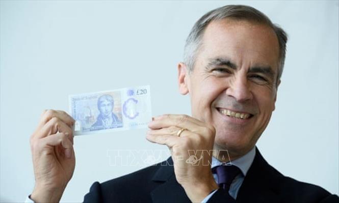 Trong ảnh: Thống đốc Ngân hàng Anh Mark Carney giới thiệu tờ tiền polymer mệnh giá 20 bảng. Ảnh: Reuters/TTXVN