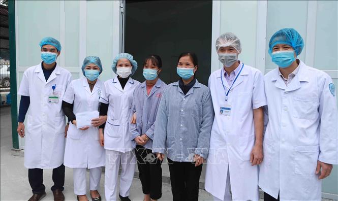 Photo: The patients with doctors and nurses of the Quang Ha Area General Clinic. VNA Photo: Hoàng Hùng