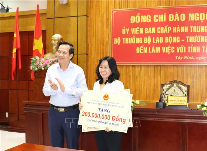 Trong ảnh: Bộ trưởng Bộ Lao động - Thương binh và Xã hội Đào Ngọc Dung tặng 400 triệu đồng để chăm lo cho người nghèo và người có công ở Tây Ninh. Ảnh: Lê Đức Hoảnh-TTXVN
