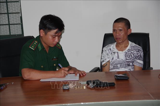 Trong ảnh: Cán bộ Đồn BP CKQT Mộc Bài lấy lời khai đối tượng Bùi Ngọc Thắng. Ảnh: Thanh Tân - TTXVN