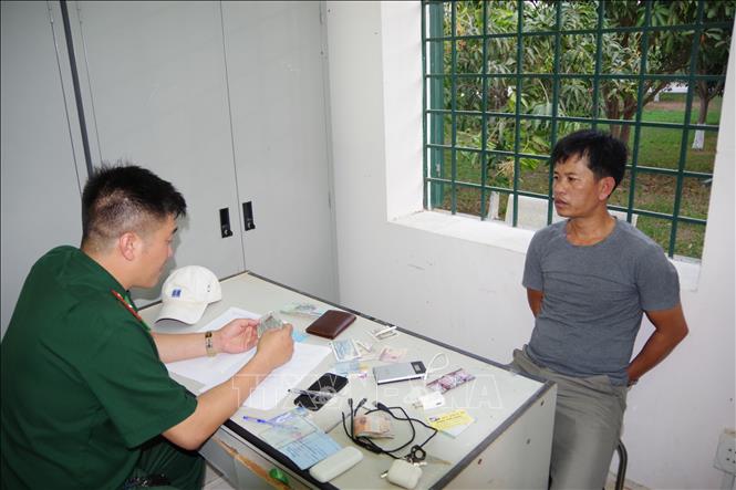 Trong ảnh: Đối tượng Trương Hùng cùng một số tang vật tại Đồn BP CKQT Mộc Bài. Ảnh: Thanh Tân - TTXVN