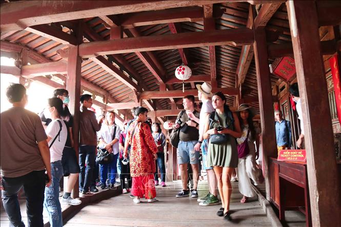 Photo: The Chua Cau (Pagoda Bridge) sees the increase of visitor these days. VNA Photo: Đoàn Hữu Trung