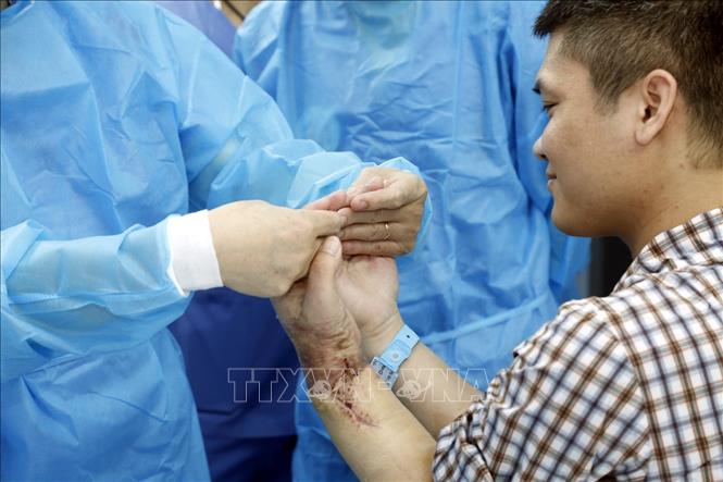 Trong ảnh: Bác sĩ Bệnh viện Trung ương Quân đội 108 kiểm tra chức năng vận động của bệnh nhân sau ca ghép “cẳng tay và bàn tay mới”. Ảnh: TTXVN phát