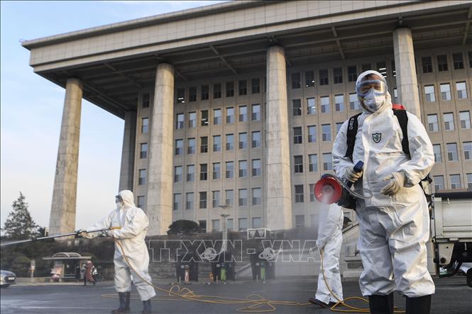 Trong ảnh: Lực lượng chức năng tiến hành khử trùng tại tòa nhà Quốc hội Hàn Quốc ở Seoul ngày 24/2/2020. Ảnh: YONHAP/TTXVN