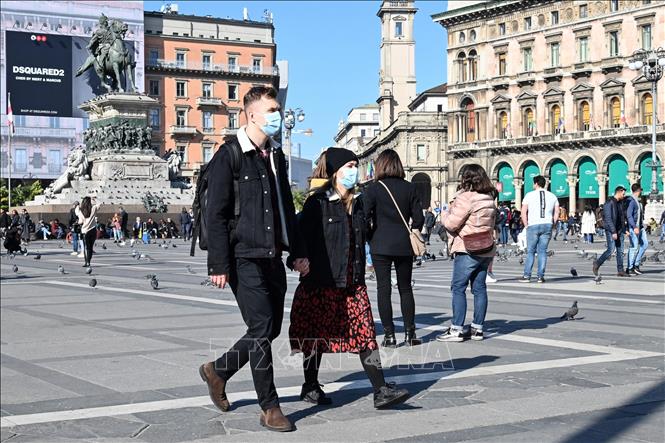 Trong ảnh: Khách thăm quan đeo khẩu trang phòng dịch COVID-19 tại quảng trường del Duomo, Milan, Italy ngày 24/2/2020. Ảnh: AFP/TTXVN
