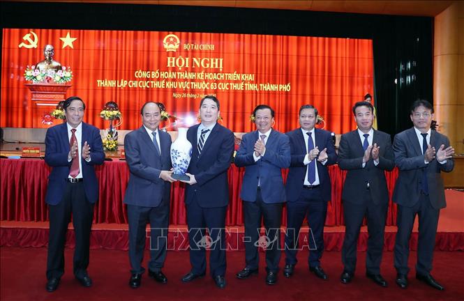 Trong ảnh: Thủ tướng Nguyễn Xuân Phúc tặng quà lưu niệm cho Tổng cục thuế . Ảnh: Thống Nhất – TTXVN