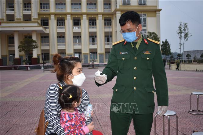Kiểm tra thân nhiệt công dân tại Trung tâm Giáo dục quốc phòng Trường Quân sự Bộ Tư lệnh Thủ đô Hà Nội. Ảnh: Nguyễn Cúc - TTXVN