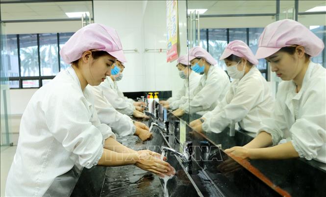 Trong ảnh: Người lao động tại Công ty TNHH Bluecom Vina, Khu Công nghiệp Tràng Duệ, An Dương rửa tay bằng xà phòng trước khi vào phòng ăn tập thể. Ảnh: Minh Thu- TTXVN