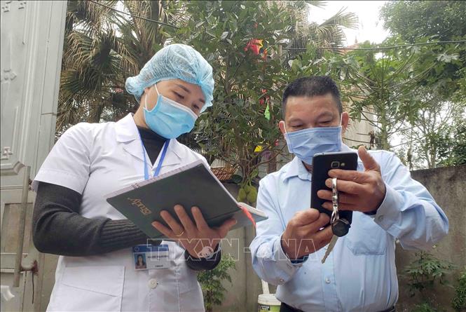 Trong ảnh: Cán bộ Trung tâm kiểm soát bệnh tật Vĩnh Phúc (áo trắng) được tăng cường xuống Trạm y tế xã Sơn Lôi kiểm tra số liệu theo dõi sức khỏe của người dân trong xã. Ảnh: Hoàng Hùng - TTXVN