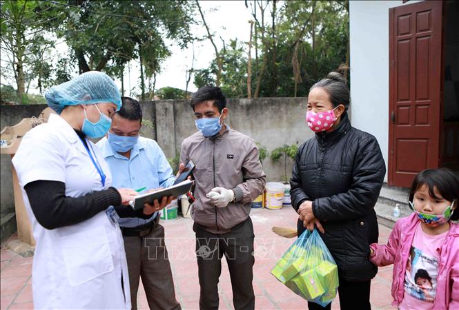 Trong ảnh: Cán bộ Trung tâm kiểm soát bệnh tật Vĩnh Phúc (áo trắng) được tăng cường xuống Trạm y tế xã Sơn Lôi kiểm tra số liệu theo dõi sức khỏe của người dân trong xã. Ảnh: Hoàng Hùng - TTXVN