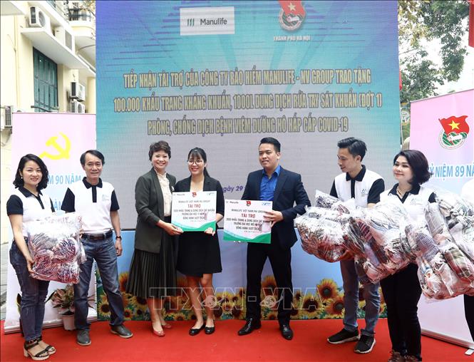 Trong ảnh: Bà Vũ Thị Hoài Nam, Phó Chủ tịch - Trưởng vùng cấp cao Manulife Việt Nam cùng cán bộ, nhân viên Manulife Việt Nam trao tặng khẩu trang cho các đơn vị tại buổi lễ. Ảnh: Văn Điệp – TTXVN