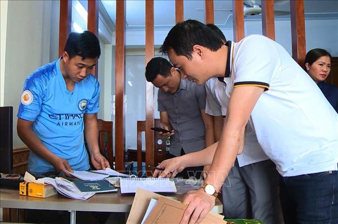 Lực lượng chức năng khám xét nhà Bùi Quốc Đạt. Ảnh: TTXVN phát