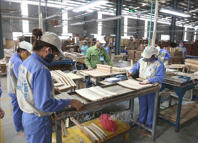 Trong ảnh: Sản xuất sản phẩm đồ gỗ nội, ngoại thất xuất khẩu tại Công ty. Ảnh: Vũ Sinh - TTXVN