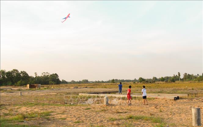 Trong ảnh: Các bãi đất trống trong thành phố Vị Thanh là nơi lý tưởng để trẻ em thả diều. Ảnh: Hồng Thái - TTXVN