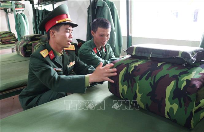 Trong ảnh: Thượng úy Nguyễn Sỹ Dũng kiểm tra quân trang tại nơi ở của tân binh. Ảnh: Nguyễn Oanh-TTXVN