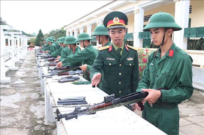 Trong ảnh: Thượng úy Nguyễn Sỹ Dũng hướng dẫn tháo lắp vũ khí cho tân binh. Ảnh: Nguyễn Oanh-TTXVN