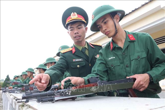 Trong ảnh: Thượng úy Nguyễn Sỹ Dũng hướng dẫn tháo lắp vũ khí cho tân binh. Ảnh: Nguyễn Oanh-TTXVN