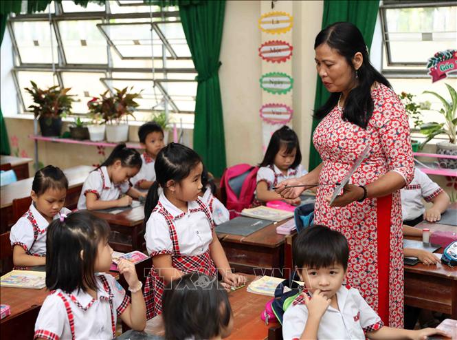 Trong ảnh: Hình ảnh người nữ giáo viên trong tà áo dài góp phần lan tỏa vẻ đẹp của áo dài, đẩy mạnh tuyên truyền, tôn vinh, quảng bá chiếc áo dài và khẳng định áo dài của là một trong những biểu tượng đẹp đẽ của đất nước, con người Việt Nam. Ảnh: Thanh Tùng-TTXVN