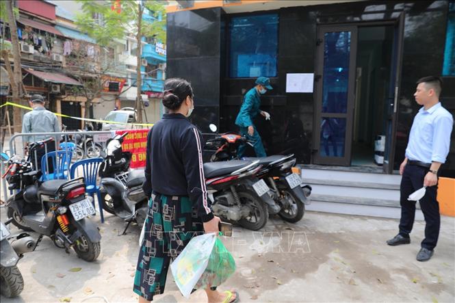 Trong ảnh: Cơ quan chức năng lắp đặt chốt kiểm soát (ở ngã tư Trúc Bạch - Ngũ Xã), người dân tiếp tế thực phẩm cho người thân phải gửi qua trạm kiểm tra. Ảnh: Thành Đạt - TTXVN