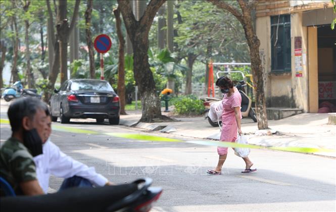 Trong ảnh: Bên trong khu cách ly phố Trúc Bạch người dân nhận lương thực, thực phẩm từ bên ngoài chuyển vào qua trạm kiểm tra an ninh đặt tại đầu phố. Ảnh: Thành Đạt - TTXVN