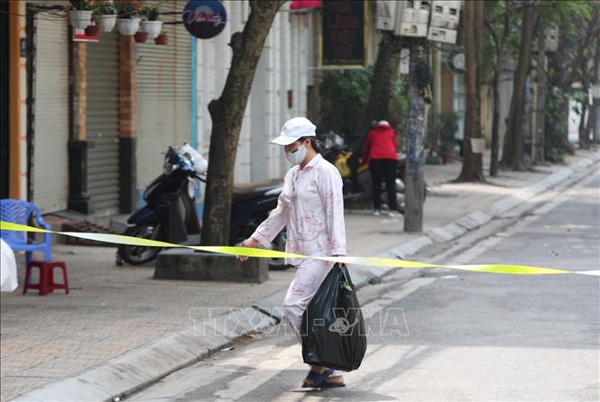 Trong ảnh: Bên trong khu cách ly phố Trúc Bạch người dân nhận lương thực, thực phẩm từ bên ngoài chuyển vào qua trạm kiểm tra an ninh đặt tại đầu phố. Ảnh: Thành Đạt - TTXVN