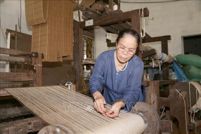 Trong ảnh: Nghệ nhân Ưu tú Phan Thị Thuận là người dệt vải từ sợi tơ sen đầu tiên ở Việt Nam. Ảnh: Phương Hoa - TTXVN