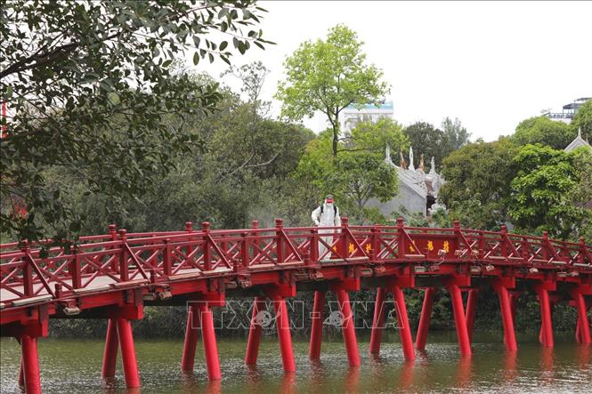 Trong ảnh: Phun thuốc tiêu độc khử trùng tại cầu Thê Húc. Ảnh: Thành Đạt - TTXVN