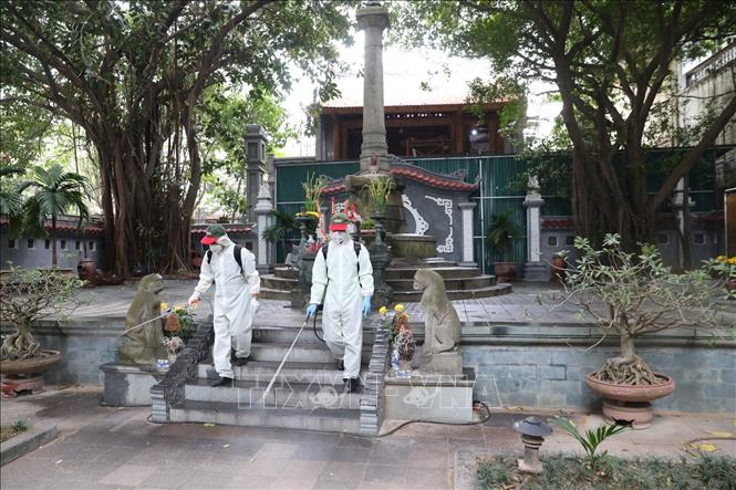 Trong ảnh: Nhân viên Sở y tế Hà Nội phun thuốc tiêu độc khử trùng khuôn viên tượng đài Vua Lê Thái Tổ. Ảnh: Thành Đạt - TTXVN