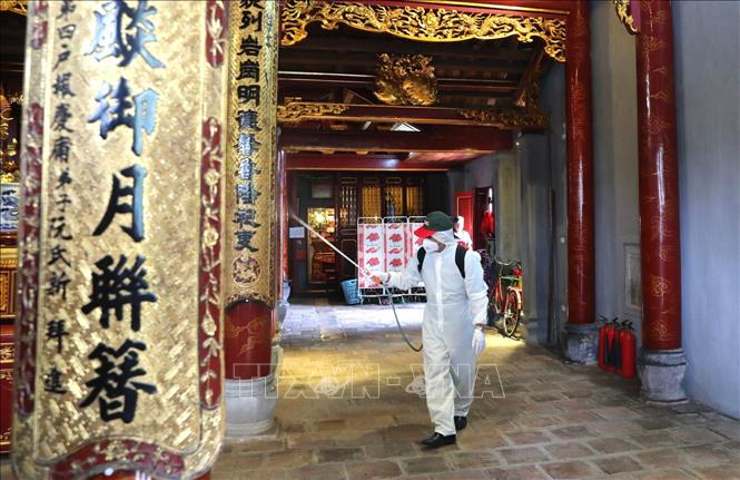Trong ảnh: Nhân viên Sở y tế Hà Nội phun thuốc tiêu độc khử trùng bên trong đền Bà Kiệu. Ảnh: Thành Đạt - TTXVN
