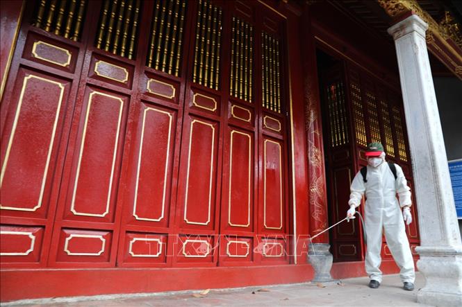 Trong ảnh: Phun thuốc tiêu độc khử trùng tại đền Bà Kiệu. Ảnh: Thành Đạt - TTXVN